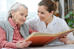 caregiver and senior reading a book